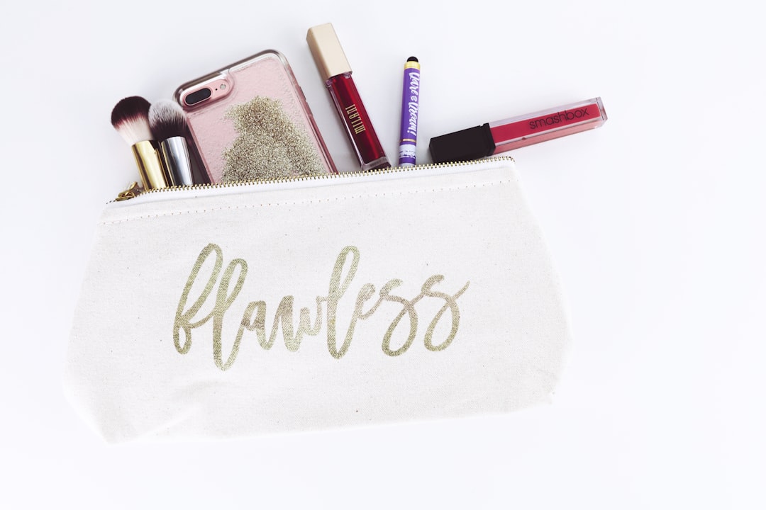 A makeup bag labeled "flawless" with brushes, lipsticks, and a phone sticking out—perfect for OEM ODM customization to suit your brand.