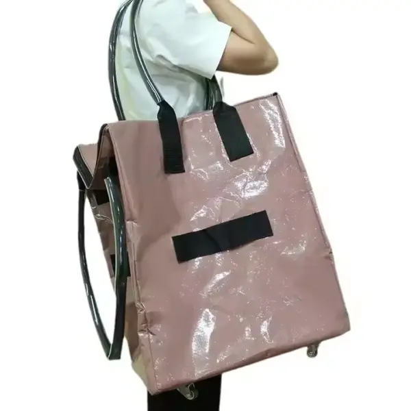 Asmuo, nešantis didelius ratu, Blizgi rožinė su juodomis rankenomis ir ratukais - iš šono, Puikiai tinka pabrėžti OEM ODM dizaino universalumą.