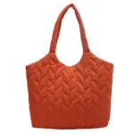 Bolso acolchado acolchado para mulleres en laranxa cun mango redondo e un patrón de chevron, mostrado nun fondo branco. Servizos OEM e ODM ofrecidos para deseños personalizados.