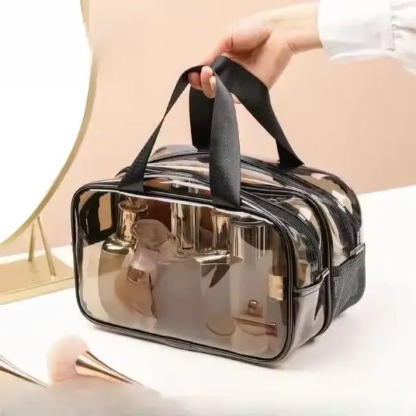 A hand holds a Black Transparent Toiletry Bag with black trim and handles on a white tabletop, highlighting its stylish design and OEM/ODM customization options.