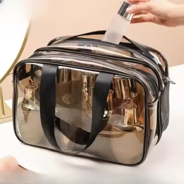 A hand is placing a bottle into the Black Transparent Toiletry Bag, which is already filled with bottles.