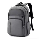 Lo zaino per laptop commerciale multi-compartment, in grigio, Dispone di compartimenti multipli e tasche laterali, mostrato in posizione verticale su uno sfondo bianco.