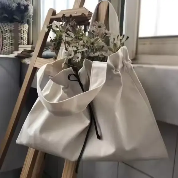 Drawstring Canvas Shopping Bag with wildflowers inside, hanging on a wooden ladder by a window—ideal for displaying OEM ODM designs in everyday style.