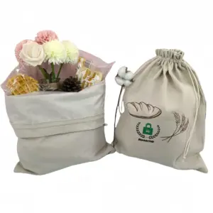 Two beige Cotton Bread Drawstring Shopping Bags—one open with flowers and snacks, one closed with a wheat design—perfect for OEM/ODM customization.