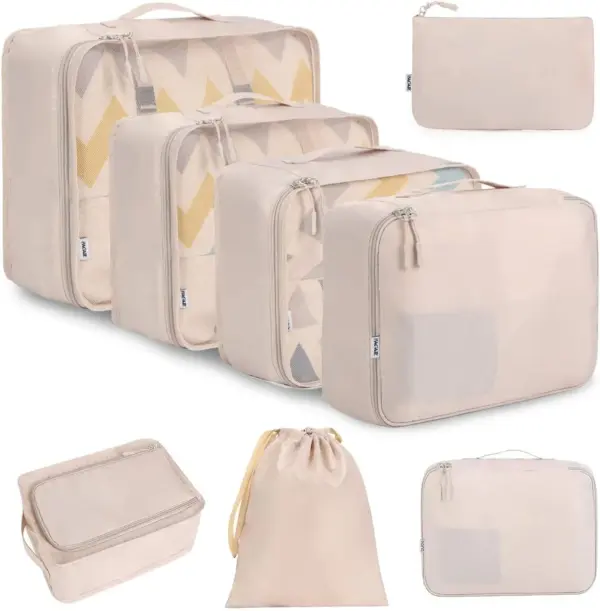 D'Geschäft Rees waasserdicht Späichere gesat an der Beige Featuren OEM ODM Packing Cubes a Poschen vu verschiddene Gréissten, arrangéiert ordentlech op engem wäissen Hannergrond.