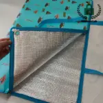 Kantong picnic Cereklroof, tepi biru, Dilu pérak, sareng pola anu disebatkeun barang-barang.