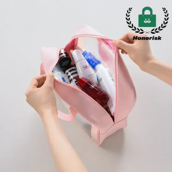 Ang mga kamot nga nagbukas sa usa ka bag nga PVC transparent toiletry bag nga puno sa mga produkto ug botelya sa skincare, gipakita gikan sa taas.