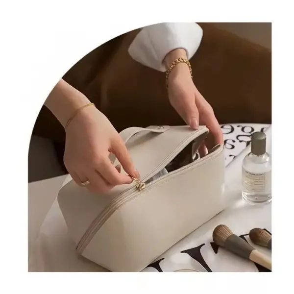 Ang usa ka tawo nagbukas sa usa ka kolor nga porsyento nga portable nga waterproof zippered makoup bag sa usa ka lamesa nga adunay mga brushes sa makeup ug usa ka botelya nga spray.