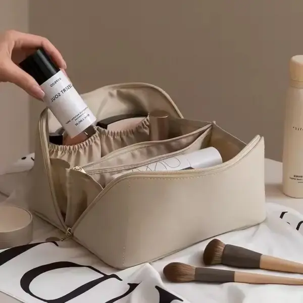 Ang portable waterproof zippered makoup bag nga naggunit mga brushes, Mga botelya sa Skincare, ug mga kosmetiko - gipakita sa usa ka kamot nga nagdugang usa ka spray nga botelya nga sulud alang sa mga kinahanglanon sa oem odm customization nga panginahanglan.
