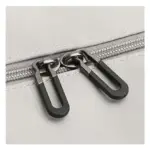 Detail dvou černých zip táhne na světle šedé látkové pozadí, zvýraznění kvality OEM ODM lehkého velké kapacity cestování.